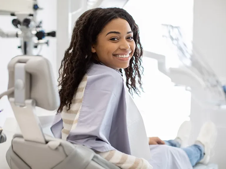 Patient Testimonials | Roots Dental Bellingham, WA - Smiling woman in dental chair after care from a cosmetic and emergency dentist in Bellingham.