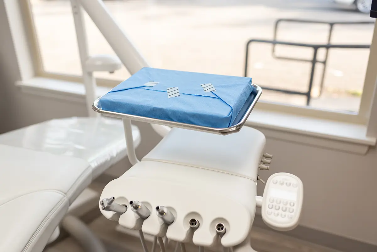 Sterilized dental instrument tray wrapped in blue protective covering at Roots Dental in Bellingham.