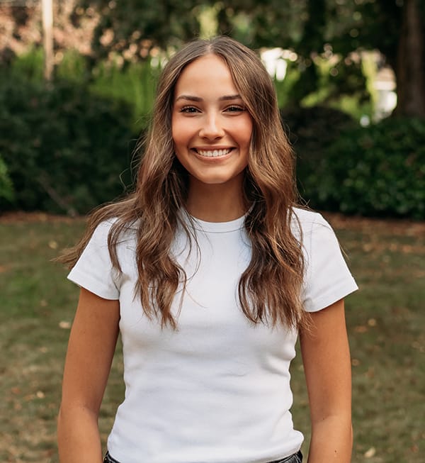 Female Roots Dental team member in Bellingham smiling outdoors.